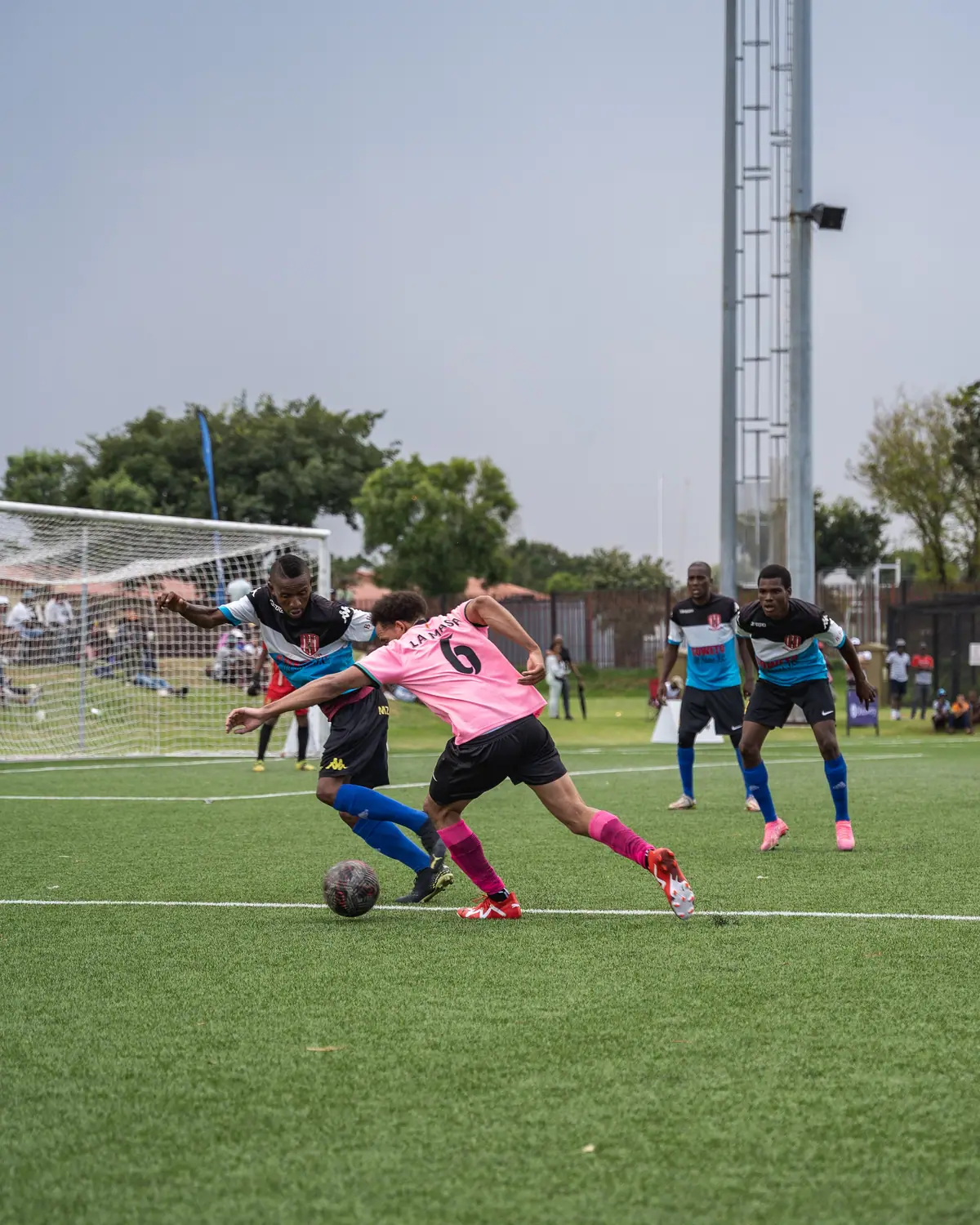 Two footballers contesting the ball on the wing
