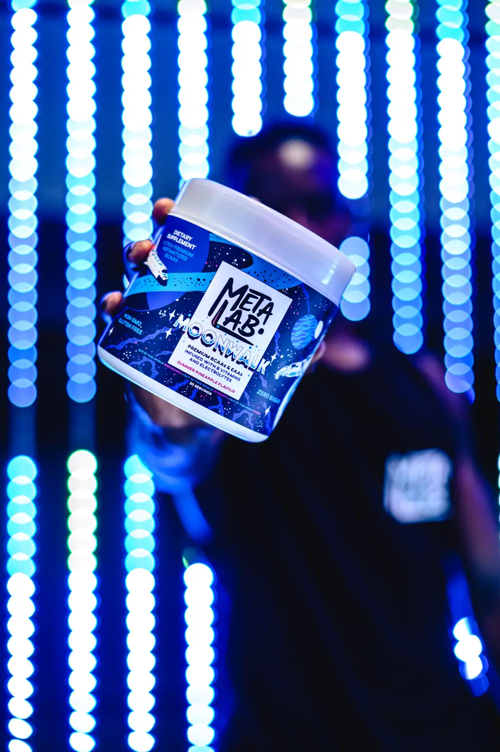 MetaLab supplement tub held up against LED lighting
