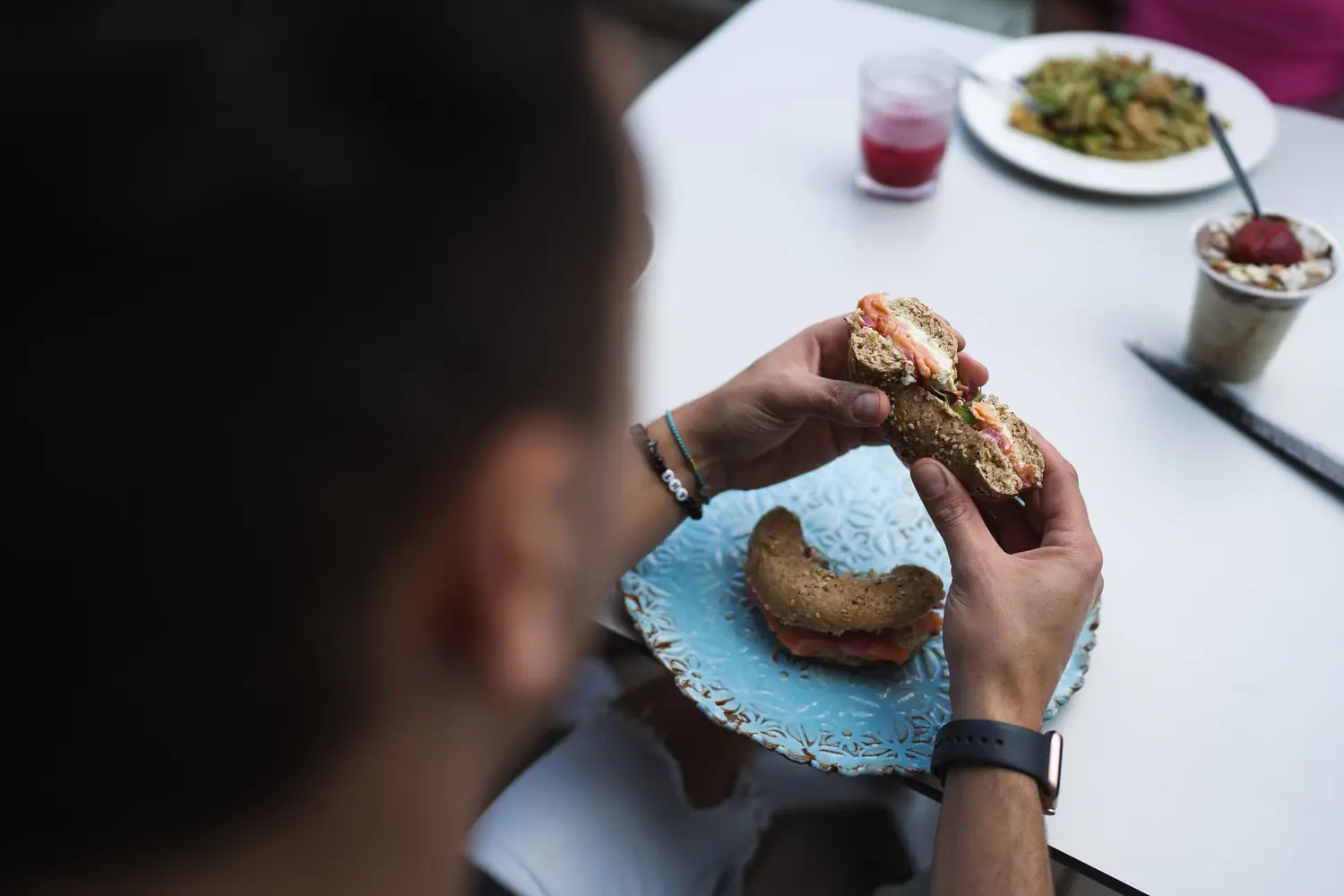 Customer eating an ONO bagel in natural light