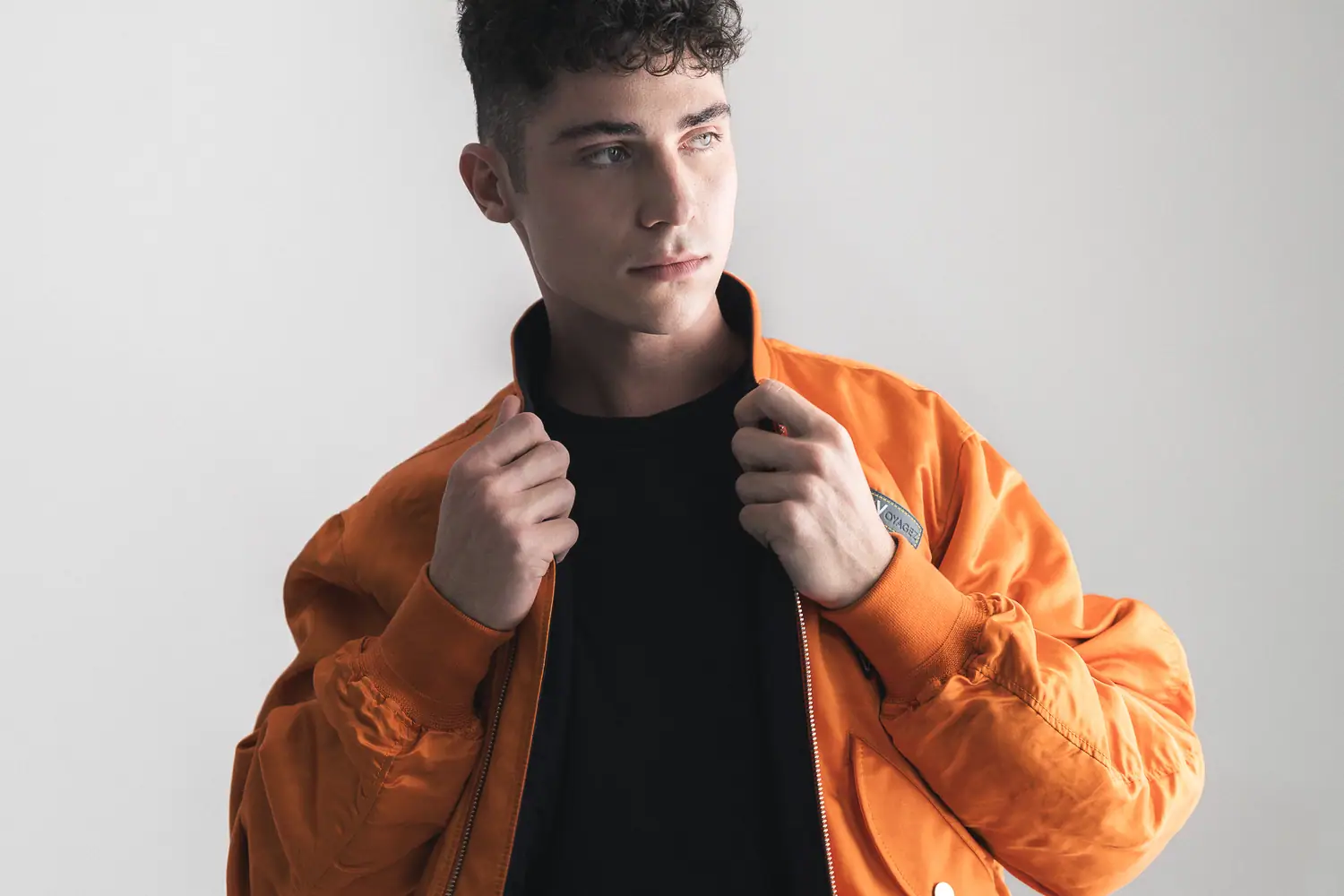 Model in an orange jacket under studio lighting